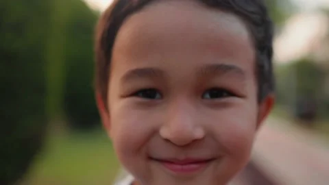 Close up view of cute smiling boy standing on alley. Portrait Little Asian Boy Stock Footage 201113171