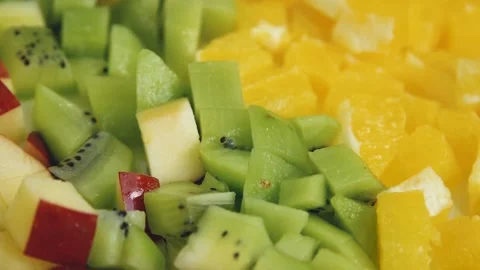 Close-up view on the cutted fruits on the table. Small pieces of oranges, kiwi Stock Footage 136823080