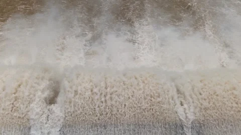 Close-up view of dam floodgate releasing strong brown water current with high pr Stock Footage 315569109