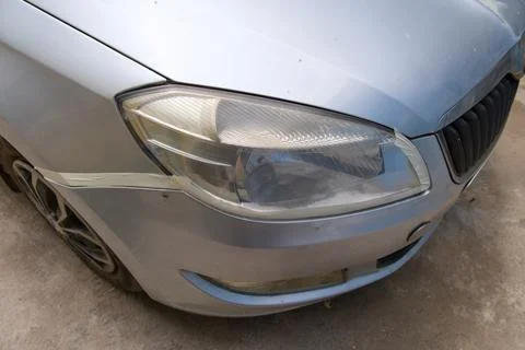 A close up view of a damaged silver car front highlighting cracked headligh.. Stock Photos