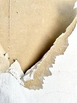 Close up view of damaged white drywall wall surface with peeling paper layer Stock Photos