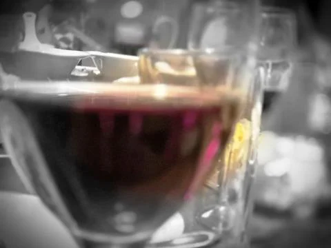 A close up view of dark coffee in a transparent glass cup with a softly blurr Stock-Fotos