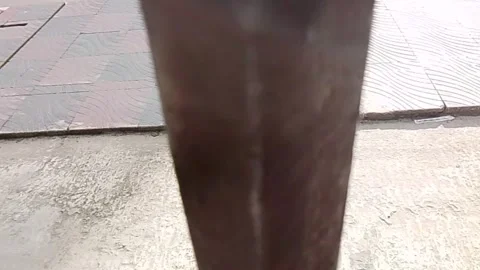 Close up view of a dark metal grill gate on a concrete street surface Video stock 343553796