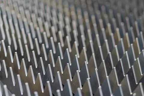 Close-up view of a dark metallic grid with uniform square protrusions, even.. Stock Photos
