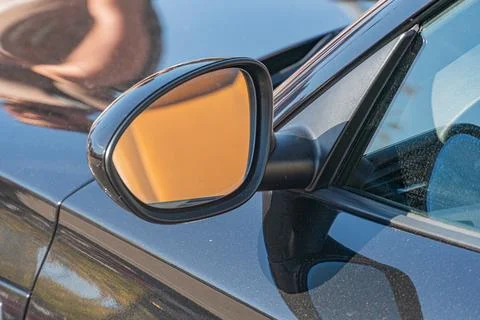 Close-up view of a dark possibly black or deep blue car parked on a street, w Stock Photos