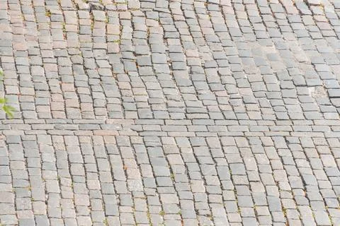 Close-up view of a dark, rectangular cobblestone street in an old European .. 스톡 사진