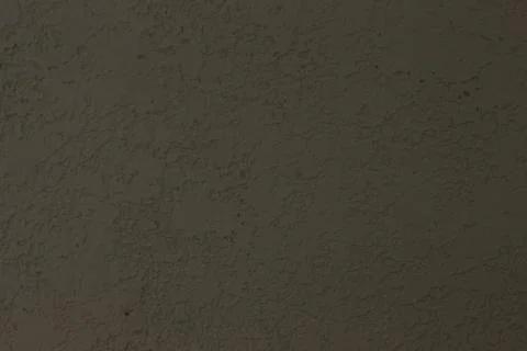 Close up view of a dark, rough textured wall with subtle rocky patterns and m 스톡 사진