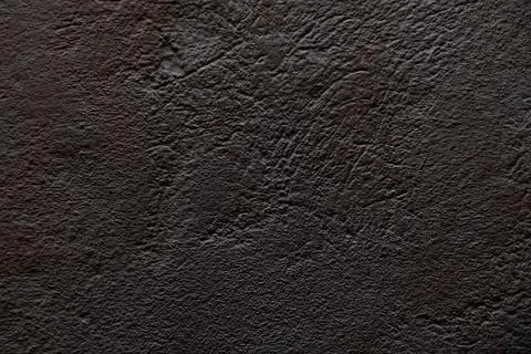 A close up view of a dark textured wall surface with rough plaster pattern, c Stock Photos