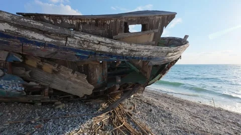 Close view of decayed wooden shipwreck bow on beach with waves Stock-Footage 337048727