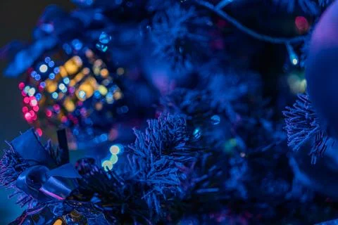 Close-up view of a decorated Christmas tree, highlighted by blue twinkling li Stock Photos