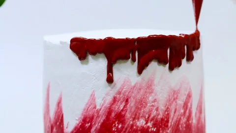 Close up view of decorating white cake with red glazing. Stock Footage 106614389