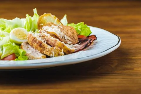 Close-up view of delicious caesar salad on wooden table Photos