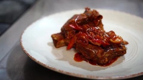 Close up view on delicious hot juicy pork ribs meat vegetable ragout under Vidéo 106979436
