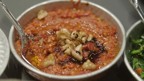 A close up view of delicious red dish garnished with walnuts on a table. Stock Footage 332891344
