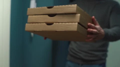 Close-up view of delivery man delivering boxes with hot pizza to client on Stock Footage 146593851