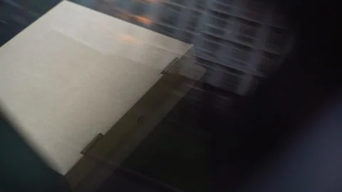 Close-up view of delivery man taking cardboard box with pizza and leaves the car Video stock 141155119