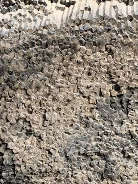 Close view of densely packed angular rock fragments forming a rugged gray and Stock Photos