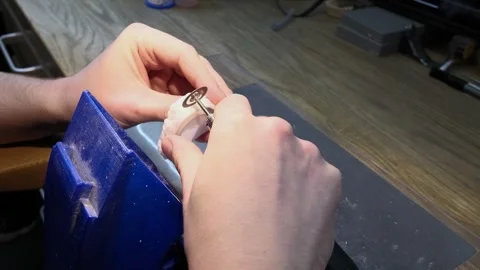 Close-up view of a dental technician's hands carefully using a rotary tool with Stock-Footage 346719868
