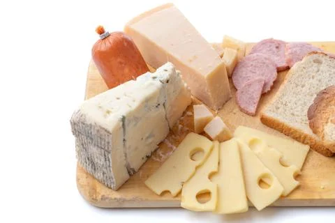 Close up view of different kinds of cheese and sausage isolated on wooden board. Stock Photos