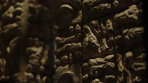 Close-up view of a dimly lit sculpted relief wall featuring clustered human Stock Footage 327531029