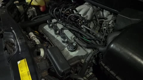 Close-up view of a dirty car engine compartment under the hood. Shows a V6 .. Stock Footage 332276493