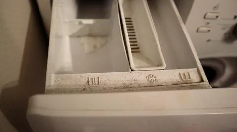 A close-up view of a dirty detergent drawer in a washing machine. Foto stock