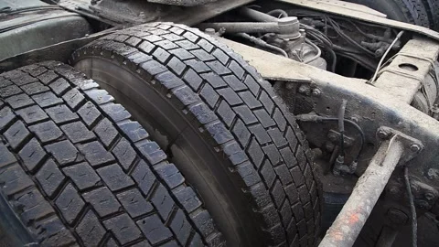 Close up view of dirty rugged heavy-duty truck tires with blocky tread pattern Stock Footage 323913678