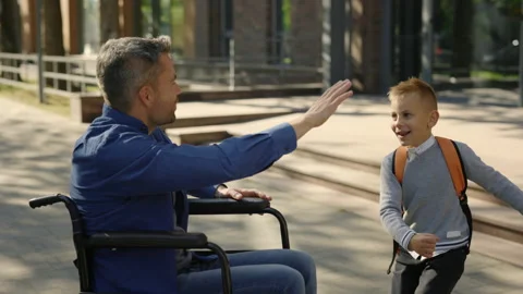 Close view of the disabled father waiting his son from the school. Happy boy Stock Footage 215136077
