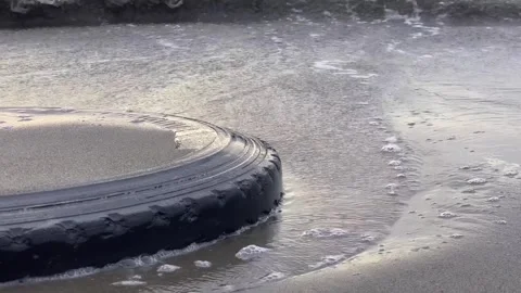 A close up view of a discarded car tire on a beach in Dagupan city. Video stock 260946879