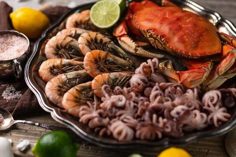 Close-up view of dish with assorted seafood served with spices on rustic wood Stock Photos