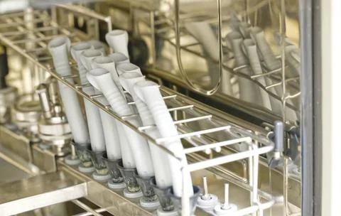 A close-up view of a dishwasher rack filled with clean, white silicone spat.. Stock Photos
