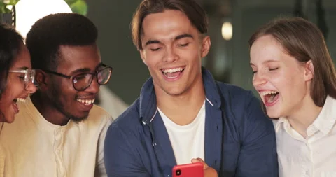Close up view of diverse friends looking at smartphone screen and laughing Stock Footage 133267955