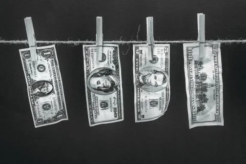 Close-up view of dollar banknotes hanging on rope isolated on black 库存照片