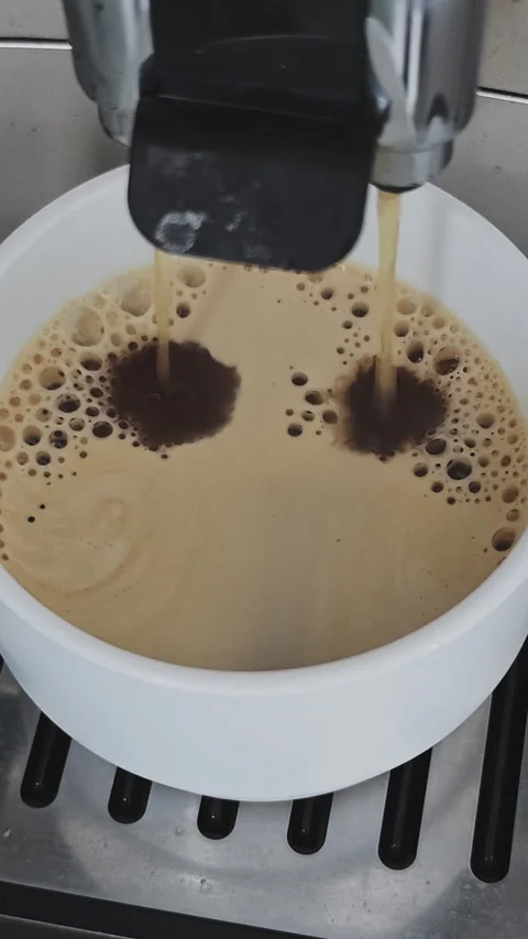 Close up view of a double espresso pouring from an automatic coffee machine Vidéo 347457876