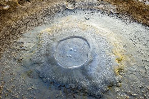 Close up view down to small boiling mud volcanoe pond with colorful textures  Fotos de archivo
