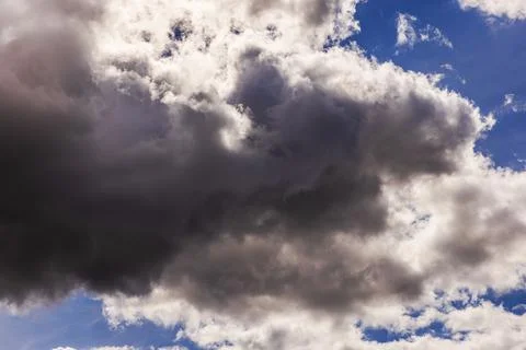 Close-up view of dramatic dark storm clouds gathering across blue sky 写真素材