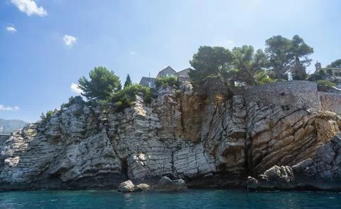 Close view of dramatic layered rock cliffs with historic stone structures and Stock Photos