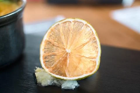 Close-up view of a dried lime slice resting on a dark surface Stock Photos
