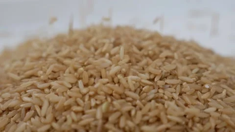 Close view of dropping brown rice, Brown rice being dropped Stock Footage 147689377