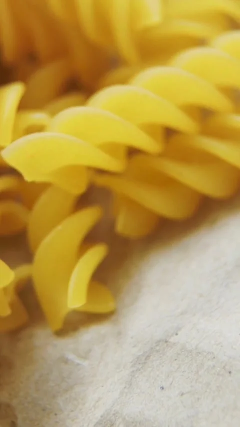 Close up view of dry yellow fusilli pasta pieces Stock Footage 334169822