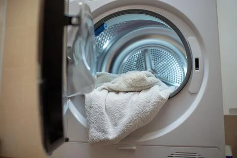 Close up view drying machine with washed and dried towels in and door open. Stock Photos
