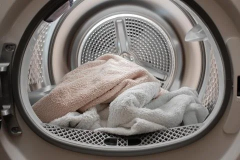 Close up view drying machine with washed and dried towels in and door open. Stock Photos