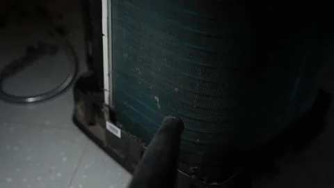 Close view of a dusty air conditioner coil being cleaned with a vacuum nozz.. 库存影片 338319411