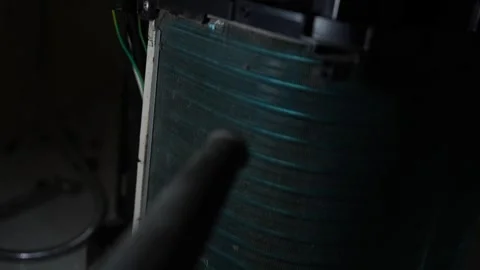 Close view of a dusty air conditioner coil in a dark indoor space with a cl.. Видео 338319413