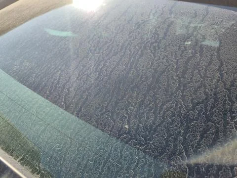 A close-up view of a dusty car windshield, showcasing intricate patterns created Stock Photos