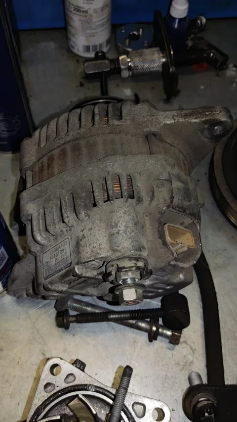 Close-Up View of Dusty, Worn Alternator on Auto Repair Workshop Bench with Tools Stock Footage 346411225