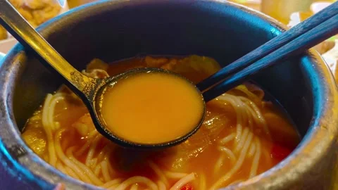 Close up view eating hot steamy boiling tomato rice noodle soup with lettuc.. Stockbeeldmateriaal 318267902
