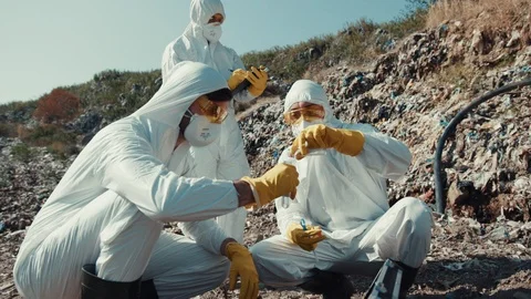 Close-up view ecology experts in protective white costumes working with toxic Stock Footage 113928478