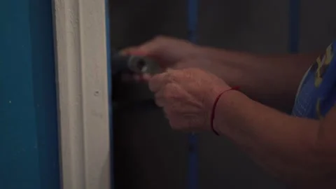 Close up view elderly woman hands uses a key, closes the old metal hanging lock Stock-Footage 155657537
