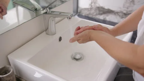 A close-up view of an elderly woman's hands as she meticulously washes them Stock Footage 336252355